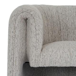 Detail of the armchair's curved back and arm, highlighting the vertical weave of the mist fabric.