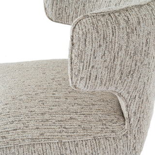 A close-up showing the junction where the upholstered seat meets the curved armrest wing, highlighting the piping.