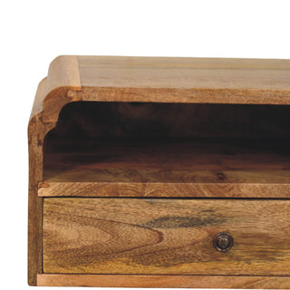 Close-up detail of the wooden bedside unit showing the curved decorative side profile and open storage shelf.
