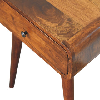 High-angle view of the chestnut nightstand top, highlighting the wood grain, rounded corners, and tapered legs.