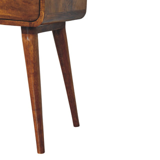 Detail shot of the tapered legs and the rounded bottom edge of the chestnut nightstand.