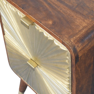 A close-up of the brass lip pull handle and the embossed sunburst texture against the chestnut wood top.