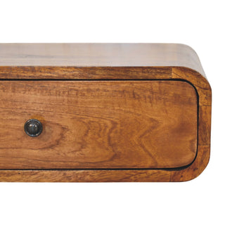 Close-up of honey caramel wood grain, dark drawer knob, and rounded corner detail.