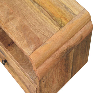 Tight close-up showing the rich wood texture and the decorative curved moulding on the top edge.