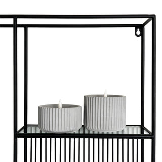 Close up showing the black metal frame, glass shelf, and top mounting hook.