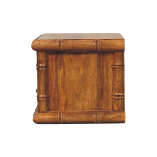 Amber oak bedside table side view, showing the depth and carved bamboo-style frame detail.