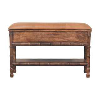 Dark wooden bench with tan leather cushion, front storage panel, and lower shelf supported by carved bamboo legs.