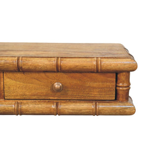 Detail shot of the console corner, highlighting the faux bamboo moulding and the single brass drawer pull.