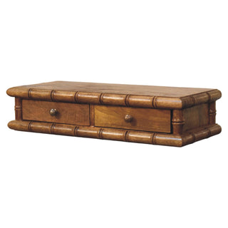 Close view of the medium brown wood grain and the detailed faux bamboo moulding surrounding the two drawers.