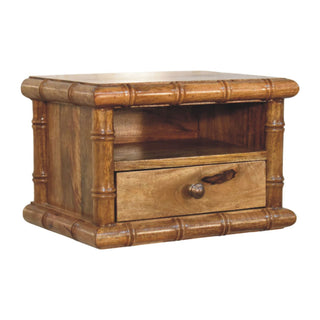 Amber oak nightstand with prominent bamboo-style carved posts framing the drawer and open storage section.