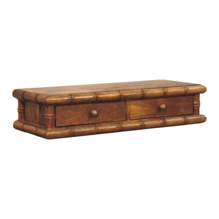 Three-quarter view of the wall-mounted console, showing the two drawers, top surface, and faux bamboo moulding.