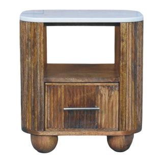 Plain front view of the bedside table with a white marble top and reeded wooden sides, open shelf, and drawer.