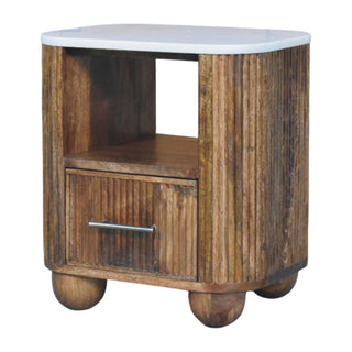 Beaumont bedside table with reeded wood body, white marble top, metal bar handle, and four rounded wooden bun feet.