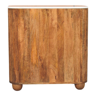 Back view of the wooden chest with vertical panelling, rounded sides, white marble top edge, and rounded bun feet.