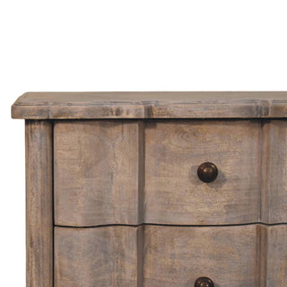 Detail of the distressed grey wood texture, curved drawer fronts, and dark bronze knob.