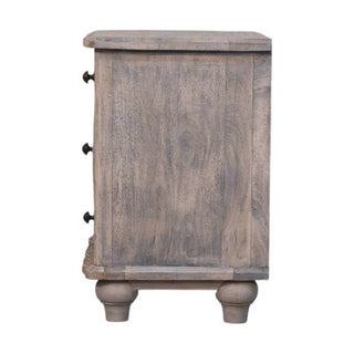 Side view of the distressed grey nightstand, highlighting the wood texture, side panel, and bun feet.
