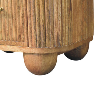 Rounded wooden bun feet supporting the base of the reeded wood bedside cabinet.
