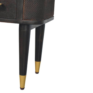 Detail of the dark wood bedside table showing the woven side panel and tapered legs with brass ferrules.