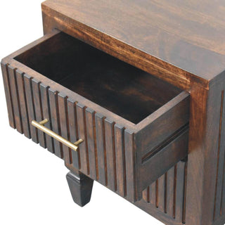 Dark wood nightstand detail with the top drawer open, showing the interior and brass handle.