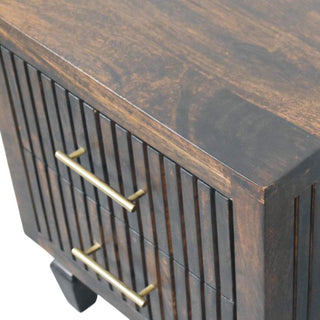 Detail shot of the dark wood top surface and the corner where it meets the fluted drawer front.