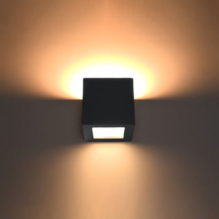 Black cubic wall light showing warm up and down lighting effect.