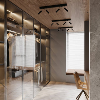 Three black four-spotlight fixtures mounted on a textured wooden ceiling above a glass-fronted wardrobe.