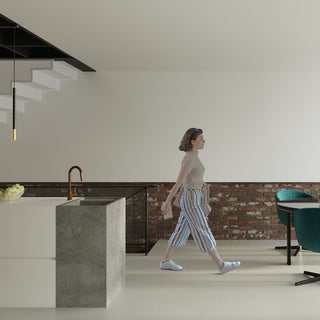 Close view of one black and gold pendant light hanging beside a perforated metal staircase.