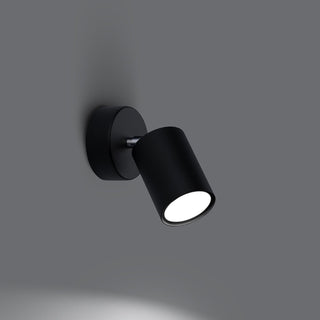 Black adjustable wall lamp angled down, showing the illuminated LED and light cast below.