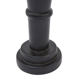 Detail close-up of the stepped, circular black wooden base of the nutcracker ornament.