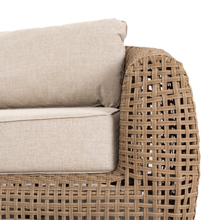 Texture detail of the sofa's thick woven arm and the neutral outdoor fabric cushions.
