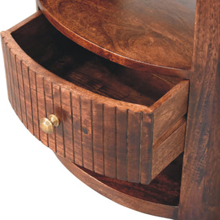 Curved fluted drawer of the bedside table pulled out, revealing the storage space and internal joinery.