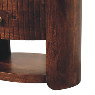 Close detail of the curved side panel, lower shelf, and the bottom edge of the fluted drawer.