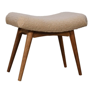 Cream boucle texture covering the deeply curved seat, supported by angled wooden legs.