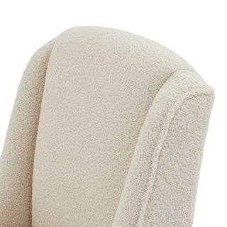 Close-up detail of the cream bouclé fabric texture and seam on the chair's curved back.