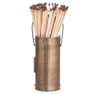 Aged bronze cylindrical holder packed tightly with long wooden matches with brown heads.
