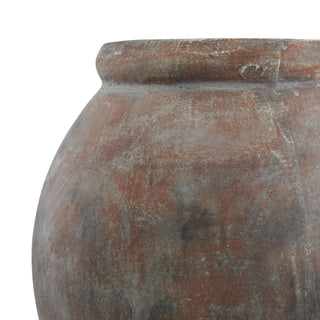 Close detail of the planter's curved body showing mottled brown and grey weathered ceramic surface.