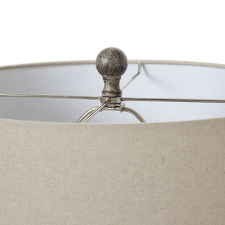 Close detail of the textured resin finial and the top edge of the beige linen lamp shade.