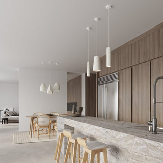 Bukano pendant lights suspended over a wooden dining table in a bright, modern kitchen interior.