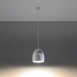 Bukano pendant light illuminated against a dark background, highlighting the downward beam and top aperture.