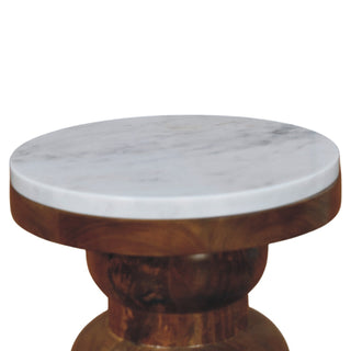 Close-up showing the circular white marble top and the polished wooden base from above.