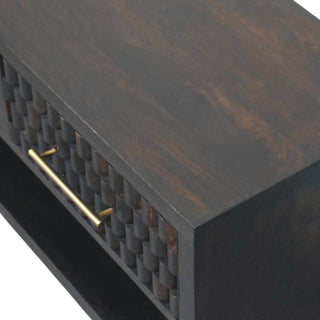 Angled close-up showing the dark wood grain finish on the bench top and the carved drawer front.