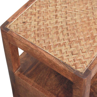 Corner detail of the dark wood bedside stand showing the woven cane inset top and the open storage compartment below.
