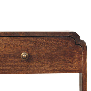 Detail of the dark walnut drawer front, showing the wood texture, brass knob, and scalloped corner.