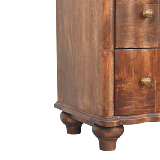 Close-up of the dark wood chest showing the turned feet, base moulding, and side panel grain.