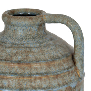 Close detail of the ribbed ceramic body and handle attachment point with mottled blue and brown glaze.