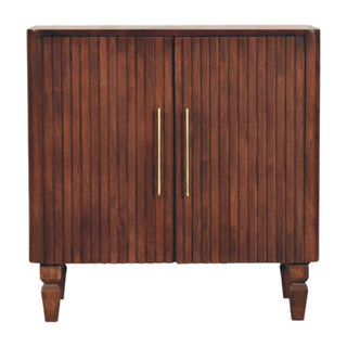 Dark wood cabinet with two fluted doors, long brass handles, and turned wooden feet.