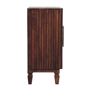 Side profile of the dark wood cabinet with fluted panelling, brass handle, and turned feet.