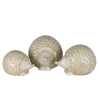 Three ceramic hedgehogs of different sizes grouped together, showing the cream and brown textured glaze.
