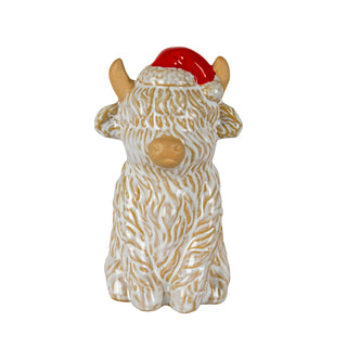 Ceramic ornament shaped like a Highland cow with textured glaze, wearing a red Santa hat.