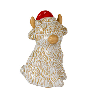 Ceramic Highland cow ornament wearing a red Santa hat. It has a textured white glaze over a tan body. Plain front-on shot.